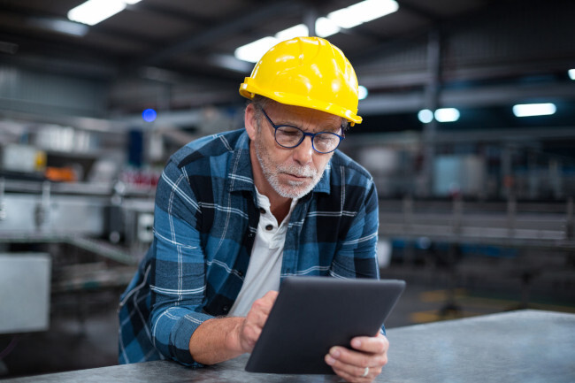 Factory worker using a digital tablet in factory